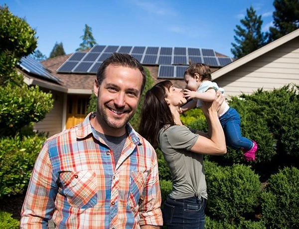 A family standing in front of a house with solar panels in Cairns.
