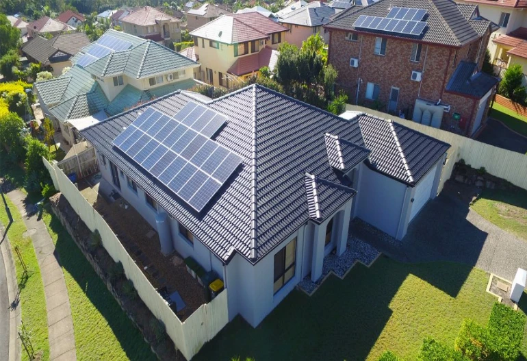 An aerial view of a house with solar panels on the roof, harnessing the power of the sun. Keywords: Solar Power