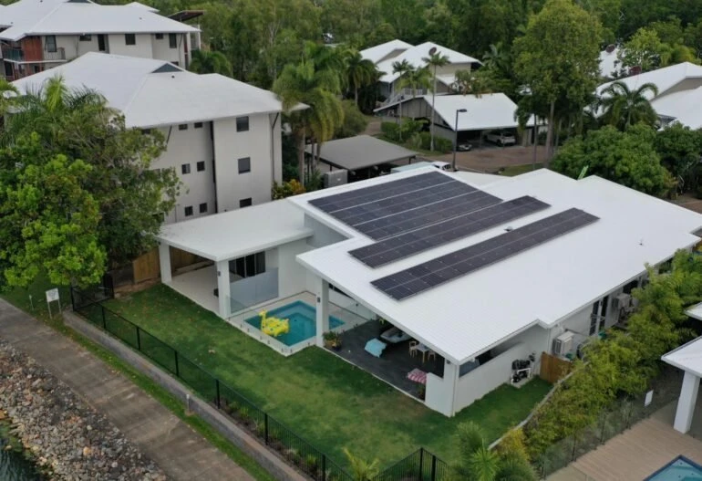 An aerial view of a house with solar panels on the roof in Cairns.