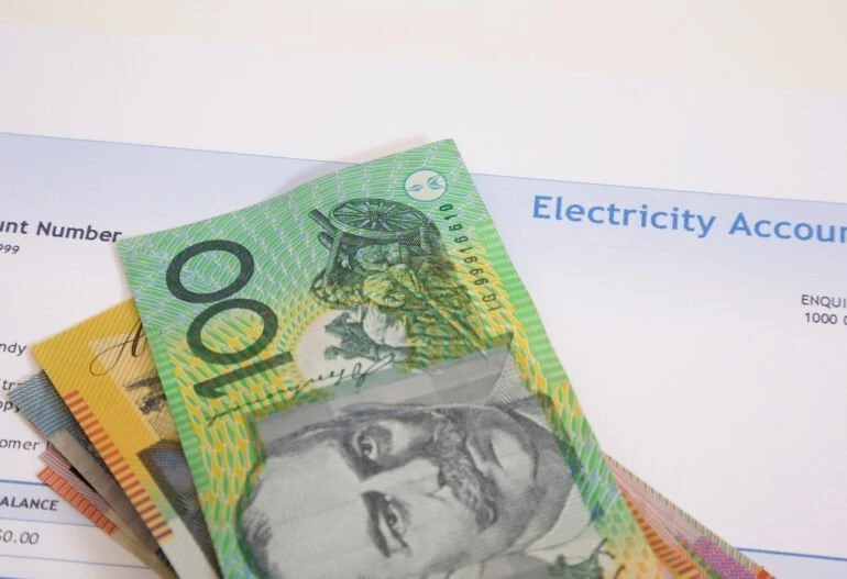 A stack of Australian dollars on top of an electricity account with Solar Power.