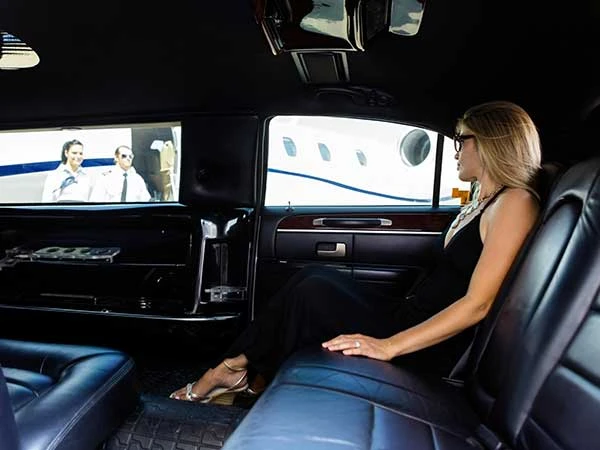 Kvinne ser på skjerm i luksuriøs bil.